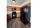 Kitchen with wood cabinets, black appliances, and vinyl flooring at 16786 E Kent Dr, Aurora, CO 80013