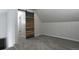Finished attic space featuring wood detail sliding barn door and neutral carpet at 3745 Fairfax St, Denver, CO 80207