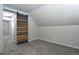 Finished attic space featuring wood detail sliding barn door and neutral carpet at 3745 Fairfax St, Denver, CO 80207