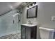 This renovated bathroom features geometric floor tiles, black fixtures, and a glass walk-in shower at 3745 Fairfax St, Denver, CO 80207