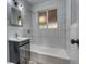 This bathroom features a tub with tiled walls, and a vanity with storage at 3745 Fairfax St, Denver, CO 80207