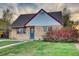 Charming brick home with a well-maintained lawn, vibrant foliage, and a pop of color from the blue front door at 3745 Fairfax St, Denver, CO 80207