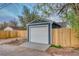 Garage exterior with a white garage door, wood fence, and concrete driveway at 3745 Fairfax St, Denver, CO 80207