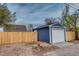 Exterior view of the detached garage with white garage door and wood fence at 3745 Fairfax St, Denver, CO 80207