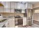 Bright kitchen with stainless appliances, granite countertops, white cabinets, and hardwood flooring at 3745 Fairfax St, Denver, CO 80207