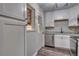 Well-lit kitchen featuring white cabinets, stainless steel dishwasher, and granite countertops at 3745 Fairfax St, Denver, CO 80207