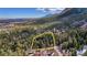 This aerial view shows the property boundary outlined in yellow with surrounding lush forest at 4835 Abo Ln, Monument, CO 80132