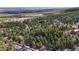Expansive aerial view shows a neighborhood nestled among rolling hills of Colorado woodland and snowy mountains at 4835 Abo Ln, Monument, CO 80132