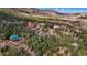 Majestic aerial view of a property surrounded by a lush forest, showcasing nearby homes and mountain vistas at 4835 Abo Ln, Monument, CO 80132