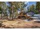 Exterior of a home showcasing a deck, garage and surrounding wooded area at 4835 Abo Ln, Monument, CO 80132