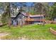 Charming multi-level home featuring a stone chimney and inviting wooden deck surrounded by lush greenery and mature trees at 4835 Abo Ln, Monument, CO 80132