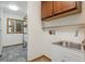 Practical laundry room has white cabinets, a sink and a storage area at 4835 Abo Ln, Monument, CO 80132