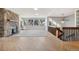 Spacious living room featuring wood floors, stone fireplace, large windows, and access to a wooden staircase at 4835 Abo Ln, Monument, CO 80132