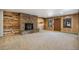 Carpeted living room features a stone fireplace and wood paneling at 4835 Abo Ln, Monument, CO 80132