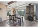 Dining room featuring a wood-burning stove, outdoor views, a wood table with seating for four, and hardwood floors at 1729 Santa Fe Mountain Rd, Evergreen, CO 80439