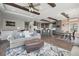 Open-concept living room featuring wood beams, hardwood floors, a kitchen island with bar seating, and modern decor at 1729 Santa Fe Mountain Rd, Evergreen, CO 80439