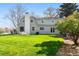 Beautiful backyard with a well-manicured lawn and a light blue house at 6990 W 9Th Pl, Lakewood, CO 80214
