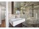 Modern bathroom featuring unique tilework, a glass shower enclosure, and sleek fixtures at 6990 W 9Th Pl, Lakewood, CO 80214