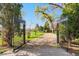 Elegant iron gate opening to a long driveway, showcasing the property's grandeur and privacy at 6990 W 9Th Pl, Lakewood, CO 80214