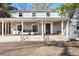 Welcoming front porch of a gray two-story home with wood deck and comfortable seating at 6990 W 9Th Pl, Lakewood, CO 80214
