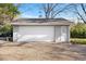 A detached garage with a large white door and gravel driveway at 6990 W 9Th Pl, Lakewood, CO 80214