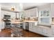 Bright kitchen featuring white cabinets, stainless steel appliances, and a butcher block island at 6990 W 9Th Pl, Lakewood, CO 80214