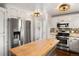 Bright kitchen featuring stainless steel appliances, ample cabinet space, and a butcher block island at 6990 W 9Th Pl, Lakewood, CO 80214