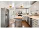 Well-lit kitchen with stainless steel appliances, white cabinetry, and a mobile island at 6990 W 9Th Pl, Lakewood, CO 80214