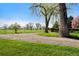 Scenic view of a gravel path, green lawn, and mature trees under a clear blue sky at 6990 W 9Th Pl, Lakewood, CO 80214