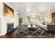 Bright living room with fireplace, large windows, light walls, dark wood flooring and stylish furniture at 6990 W 9Th Pl, Lakewood, CO 80214