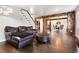 Inviting living room featuring hardwood floors, a leather sofa and ottoman, and stairs to the upper level at 6990 W 9Th Pl, Lakewood, CO 80214