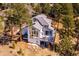 Aerial view of a house with a wooden deck in a neighborhood surrounded by trees and natural landscape at 2122 Cramner Ct, Evergreen, CO 80439