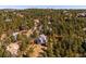 High aerial view of a home nestled in a lush forest with surrounding trees at 2122 Cramner Ct, Evergreen, CO 80439