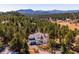 Stunning aerial view of home nestled among the trees, with mountain views in the background, offering privacy at 2122 Cramner Ct, Evergreen, CO 80439