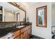Stylish bathroom featuring a vanity with a granite countertop and framed mirror at 2122 Cramner Ct, Evergreen, CO 80439