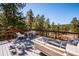 Large deck offers outdoor seating with views of the surrounding trees and neighborhood at 2122 Cramner Ct, Evergreen, CO 80439