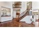 Entryway features beautiful hardwood floors, staircase with wrought iron railing, and views to dining area at 2122 Cramner Ct, Evergreen, CO 80439