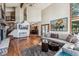 Spacious living room offers a stone fireplace, hardwood floors, and seamless access to other living spaces at 2122 Cramner Ct, Evergreen, CO 80439