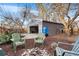 Backyard with detached garage, chairs around a fire pit, and wooden fence, perfect for entertainment and relaxing at 1623 Dayton St, Aurora, CO 80010