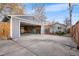 View of detached garage with driveway, adjacent to a quaint backyard, offering ample parking and outdoor access at 1623 Dayton St, Aurora, CO 80010
