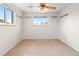 Bright bedroom with neutral carpet, white walls, ceiling fan, and large window showcasing the outside view at 7162 Quay St, Arvada, CO 80003