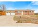 Charming brick home featuring an attached two-car garage and well-maintained front yard at 7162 Quay St, Arvada, CO 80003