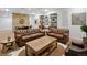 Finished living area with leather couches, wood coffee table, and stone accent wall at 7162 Quay St, Arvada, CO 80003