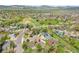 Neighborhood aerial view of a suburban community, featuring green spaces, mature trees, and a serene lake in the distance at 4734 S Garland St, Littleton, CO 80123