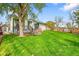 A spacious, well-maintained backyard featuring a lush green lawn, a fence, and a deck attached to the home at 4734 S Garland St, Littleton, CO 80123