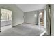 Spacious bedroom with neutral tones, grey carpet, large window, and an ensuite bathroom entrance at 4734 S Garland St, Littleton, CO 80123