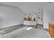 Open-concept living room with vaulted ceiling, wood floors, and a kitchen island at 4734 S Garland St, Littleton, CO 80123