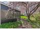 Backyard patio view features blossoming trees, manicured flowerbed and privacy fencing at 6660 E Floyd Ave, Denver, CO 80224