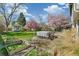 Large, private backyard oasis with raised garden beds, covered hot tub, and lush landscaping at 6660 E Floyd Ave, Denver, CO 80224