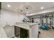 View of finished basement showcasing the bar area, lighting, and gym equipment at 6660 E Floyd Ave, Denver, CO 80224